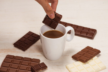 Glass of chocolate milk and bars chocolates  on table
