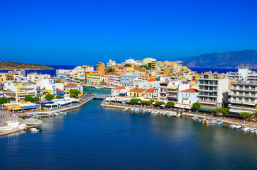 Fototapeta na wymiar The lake Voulismeni in Agios Nikolaos, a picturesque coastal town with colorful buildings around the port in the eastern part of the island Crete, Greece
