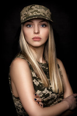 portrait of beautiful woman soldiers in military attire on black background