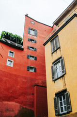Fototapeta na wymiar Traditional red, yellow old walls, wooden shutter windows in Bergamo, Italy.