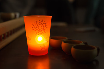 Chinese Tea cups and aromatic candle in the dark
