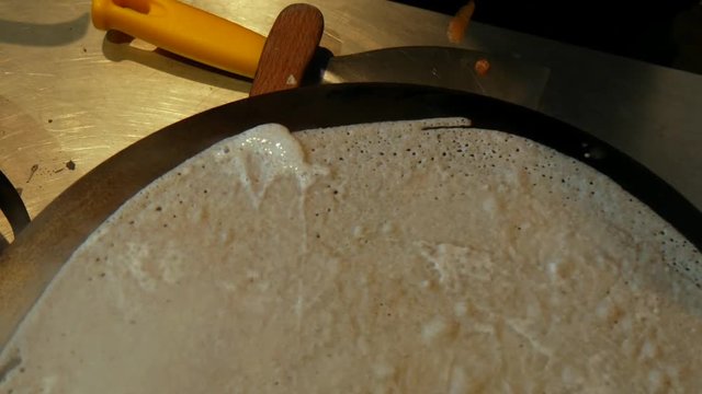 4K close up of a crepe cooking and heating, or buckwheat pancake, in Brittany. French traditional food specialty.  Galette bretonne, cr&ecirc;perie, Rennes, Bretagne, France.