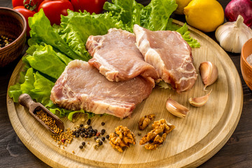 Slices of raw meat. Pork escalope on a wooden board.