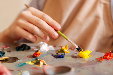 Inventive kid mixing colors in the art studio