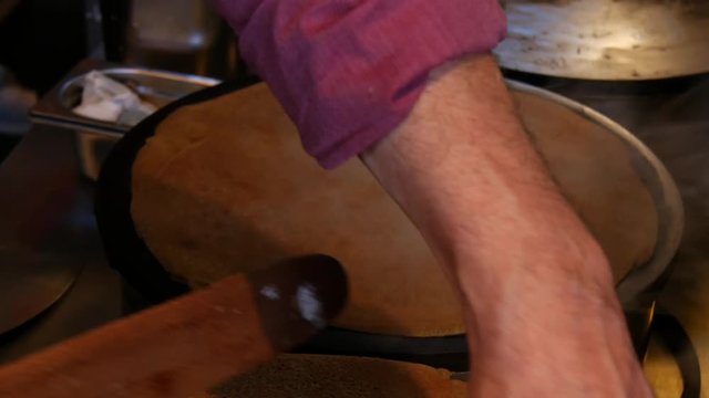 4K close up of a crepe cooking and heating, or buckwheat pancake, in Brittany. French traditional food specialty.  Galette bretonne, cr&ecirc;perie, Rennes, Bretagne, France.