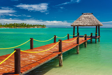 Wooden red jetty extending to tropical green lagoon, Fiji