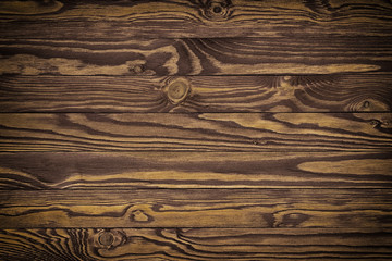 Naklejka premium Dark brown scratched wooden cutting board. Wood texture background