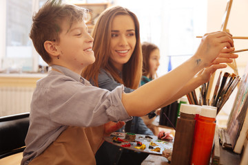 Enthusiastic young teacher helping children in the art studio