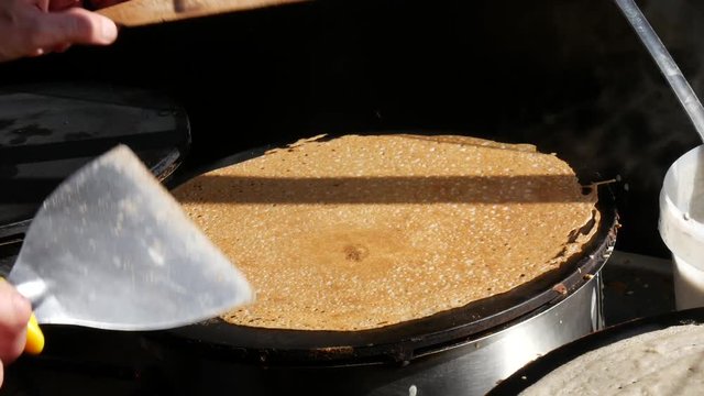 4K close up of a man flipping a crepe , or buckwheat pancake, in his cr&ecirc;perie restaurant, in Brittany. French traditional food.  Galette bretonne, creperie, Rennes, Bretagne, France.