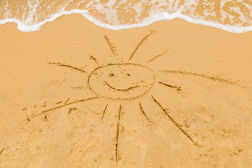 Sun drawing in the sand of ocean / sea beach.