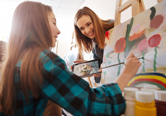 Amused teacher explaining new topic in the art school