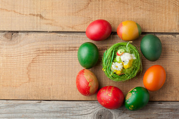 Red easter eggs on old wood table with feather and chicken