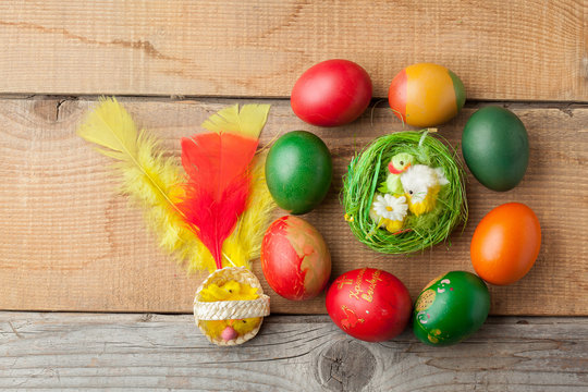 Red easter eggs on old wood table with feather and chicken