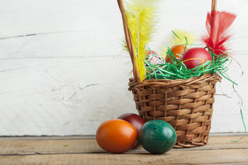 Easter eggs in basket and natural wooden country table copyspace