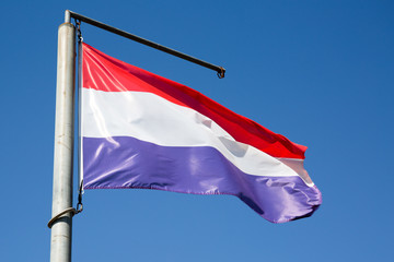 Flag of the Netherlands floats in the sky and the wind