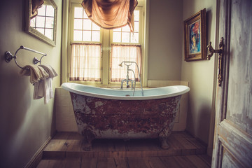 View of the vintage bathroom with old tub near the window