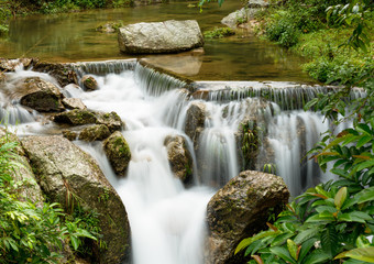 Fototapeta na wymiar Beautiful view of waterfall landscape. Small waterfall in deep green forest scenery