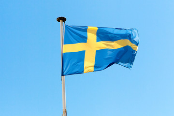 flag of Sweden in the wind and a blue sky