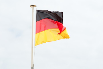 The German flag floats in the cloudy sky
