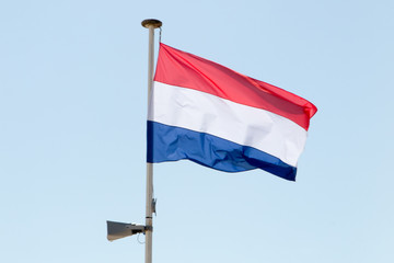 The flag of the Netherlands in the wind hanging on its mat