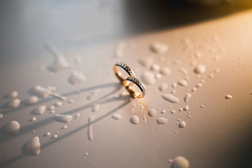 Two beautiful wedding rings on wet background