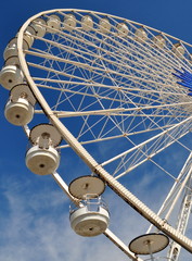 Weißes Riesenrad mit weißen Gondeln vor strahlend blauem Himmel im Hafen von Marseille