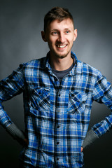 Fototapeta premium Cheerful young man in plaid shirt smiles