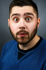 Obraz premium Funny bearded man with hazel eyes looks shoked