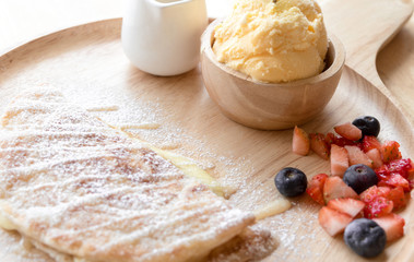 fresh dessert soft vanila roti with ice cream ,syrup ,strawberry and blueberry on plate in restaurant ,selective focus.