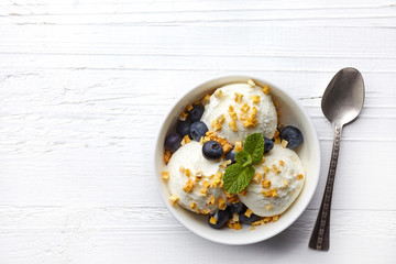 Bowl of vanilla ice cream with mango and blueberries