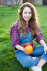 Happy young girl with orange, outside, healthy food concept. lifestyle