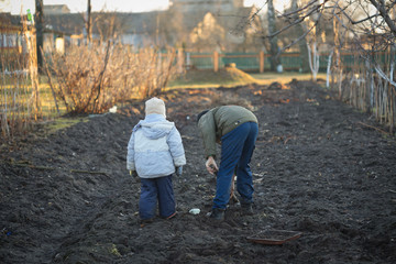 Village children dig a vegetable garden in the spring