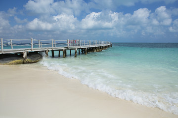 Fototapeta na wymiar Long pier on the beach of the Caribbean sea.