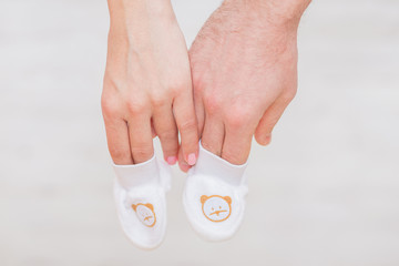 pregnant woman's belly with baby socks,mother hand holding newborn baby sock,