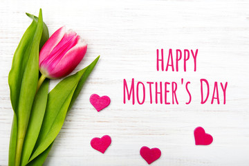 Mother's day card with tulip flower and small heart on white wooden background © czarny_bez