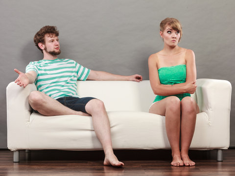Man and woman in disagreement sitting on sofa