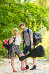 Hiking young couple with guitar backpack outdoor