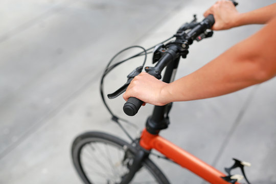 Woman riding a bicycle. Closeup on handlebar with female hand. Healthy lifestyle and sport concept