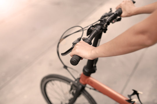 Fototapeta Woman riding a bicycle. Closeup on handlebar with female hand. Healthy lifestyle and sport concept