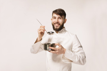 Aroma of a dish. Head chef smelling the food standing against white background. Chef smelling the...