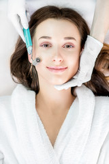 Making dry needlying procedure on woman's face in the cosmetology office