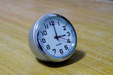 Retro alarm clock with five minutes to twelve o'clock. Old style filtered photo