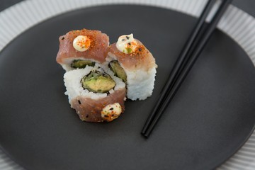 Sushi served on plate with chopsticks