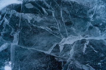 Abstract background of ice and cracks on the surface of frozen Lake Baikal