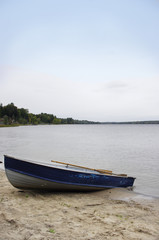 rustic blue boat on beach at river