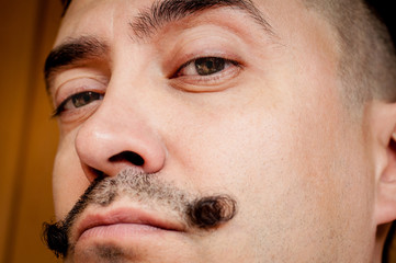 Face of a young man with a mustache close-up