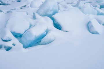 Fototapeta na wymiar Blue frozen water covered with snow at Baikal lake during winter