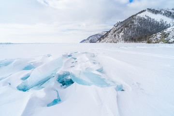 Blue frozen water covered with snow at Baikal lake during winter