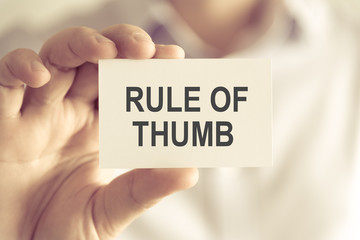 Businessman holding RULE OF THUMB message card
