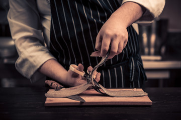 Chef cutting the fish on a board